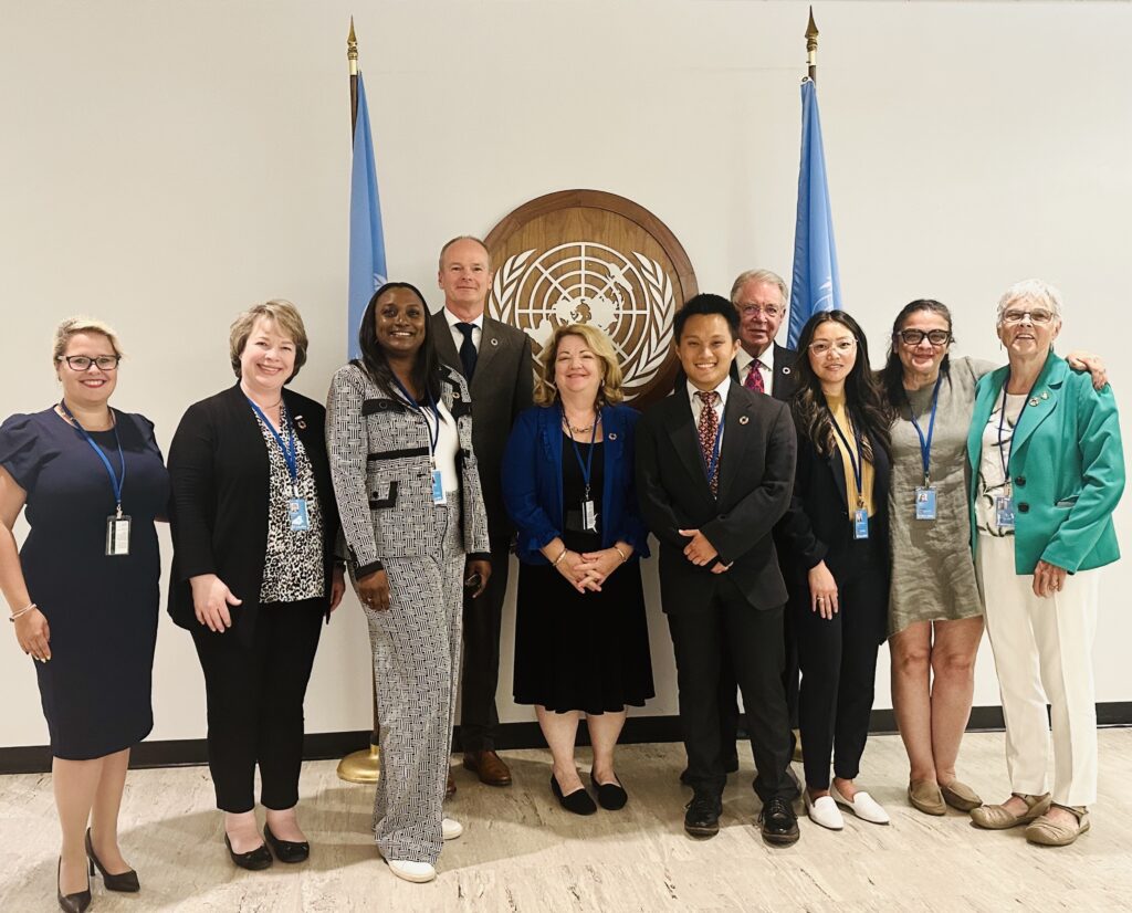 a group of ifma members standing in front of the UN symobl